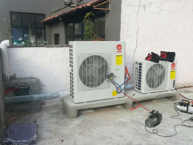 Condensadoras Trane instaladas sobre base de concreto con bomba de vacío y manómetros
